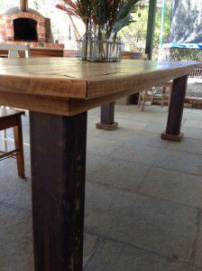 Reclaimed timber table with rusted industrial steel legs.